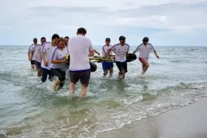 Team comes out of the sea holding their raft